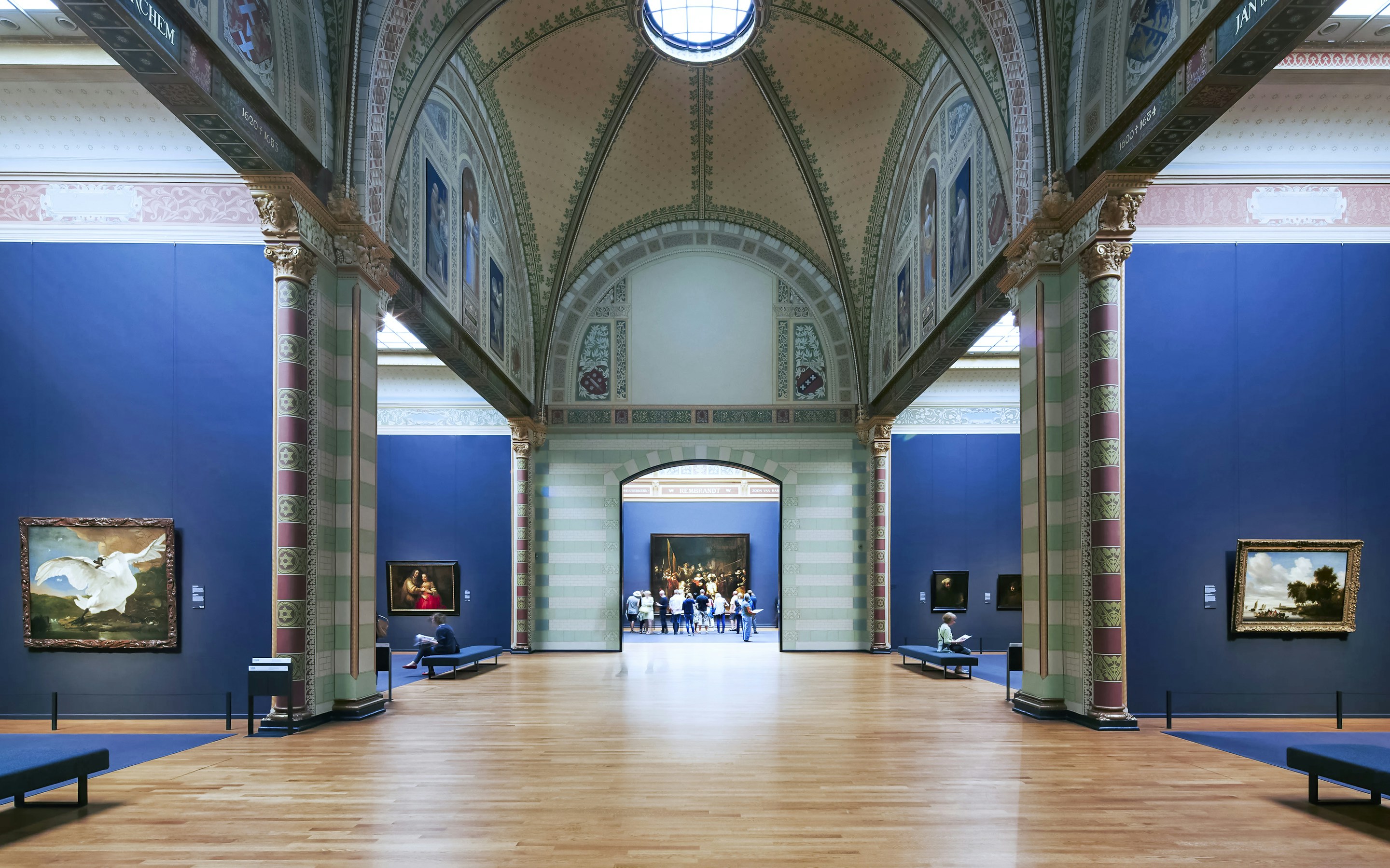 Gallery of Honor at Rijksmuseum, Amsterdam, featuring classic paintings and visitors exploring the exhibits.