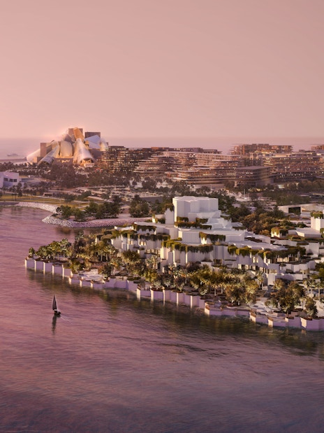Aerial view of National History Museum Abu Dhabi at sunset, surrounded by water and cityscape.