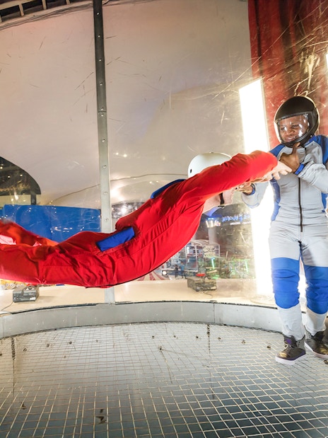 Person skydiving indoors with instructor at iFly Dubai.