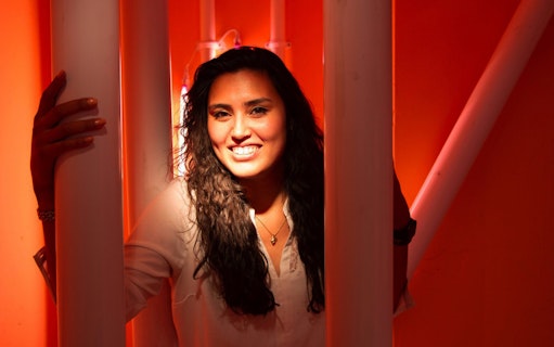 Person smiling in a vibrant orange room at Youseum Museum, Amsterdam.