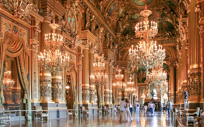 Grand foyer of Opera Garnier with ornate chandeliers and gilded decor, Paris.