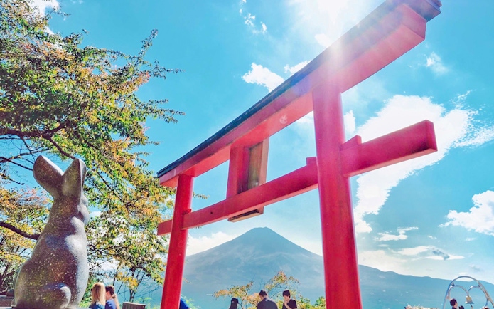 Red torii gate and rabbit statue with Mt. Fuji in the background.