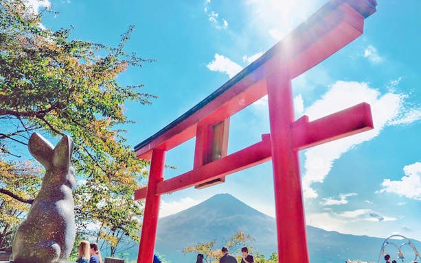 Red torii gate and rabbit statue with Mt. Fuji in the background.