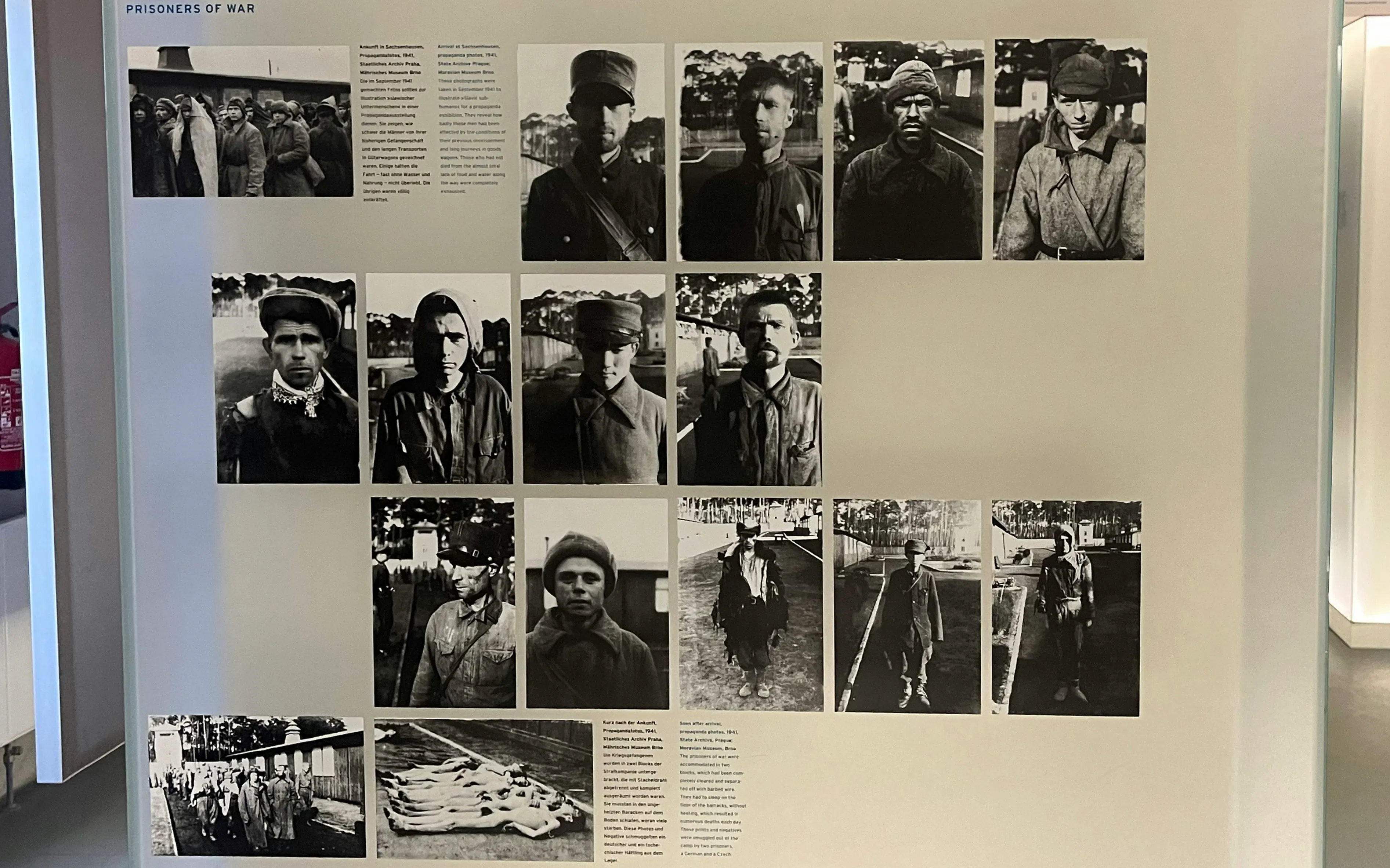 Historical exhibit of WWII prisoners of war at Sachsenhausen, Germany, featuring black and white photographs.