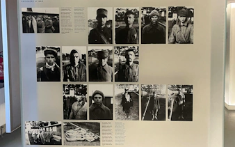 Historical exhibit of WWII prisoners of war at Sachsenhausen, Germany, featuring black and white photographs.