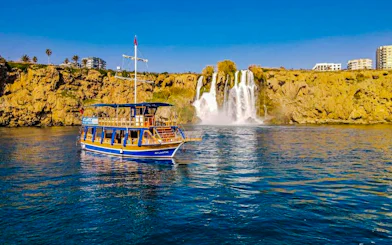 Boat near Duden Waterfall on a sunny day in Antalya.