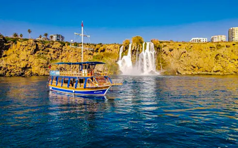 Boat near Duden Waterfall on a sunny day in Antalya.