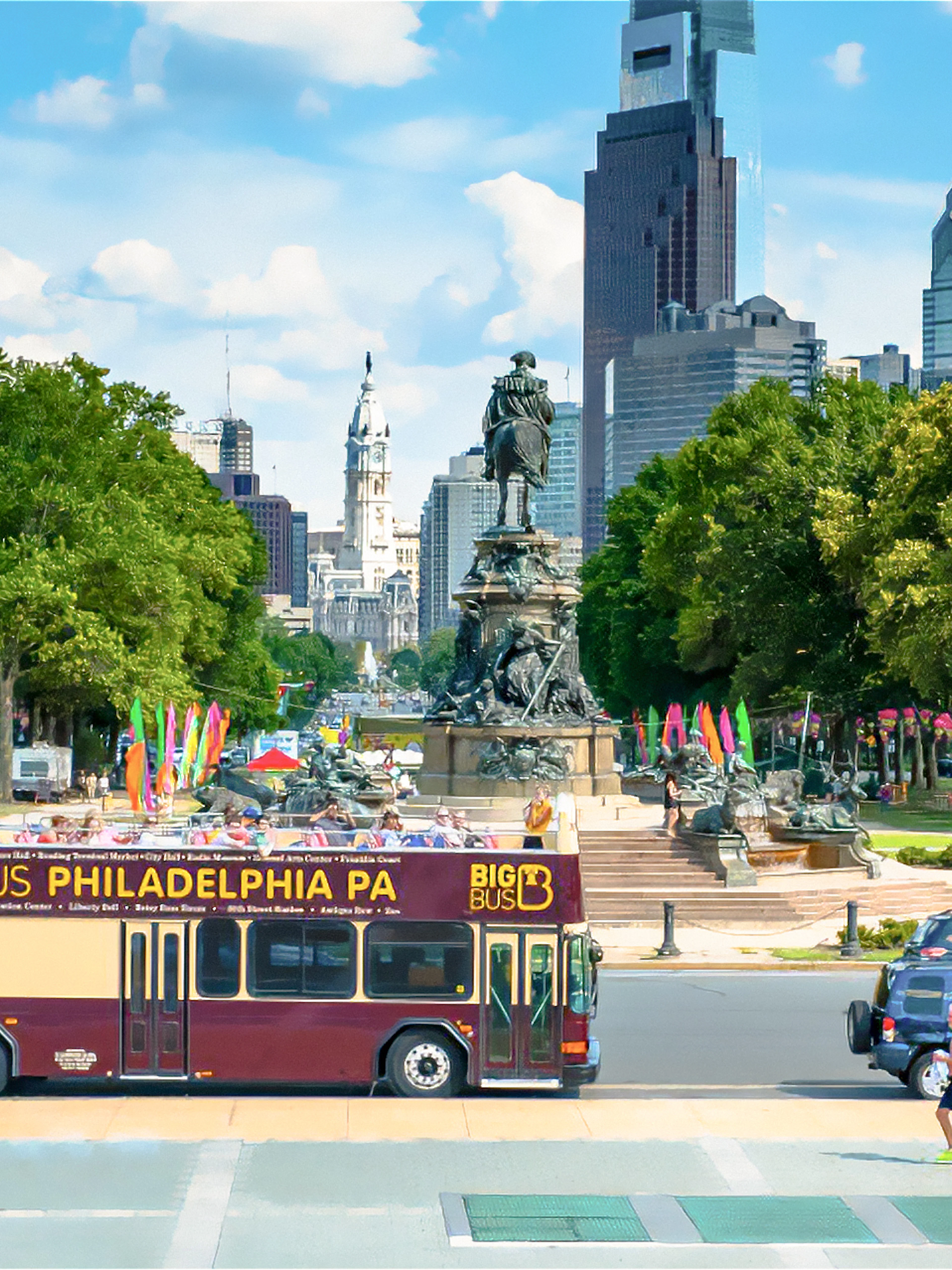 Big Bus tour in Philadelphia passing by the Benjamin Franklin Parkway with city skyline.