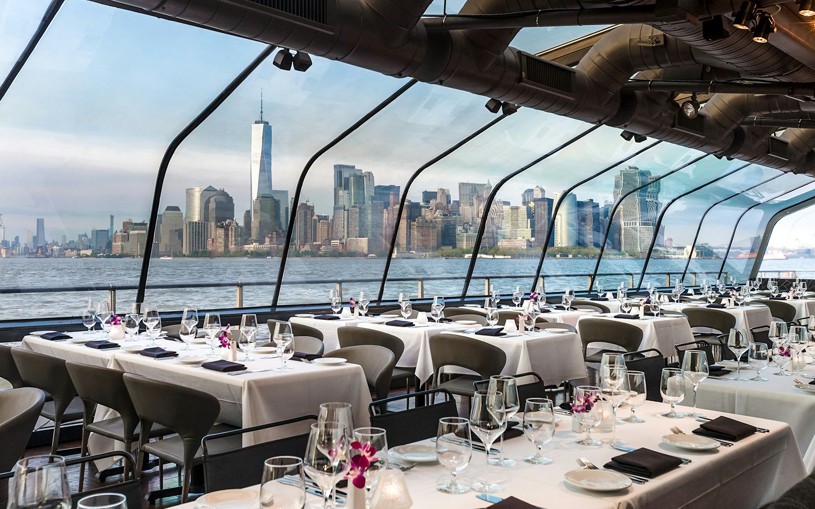 Bateaux New York Premier Dinner Cruise with skyline view of Manhattan at sunset.