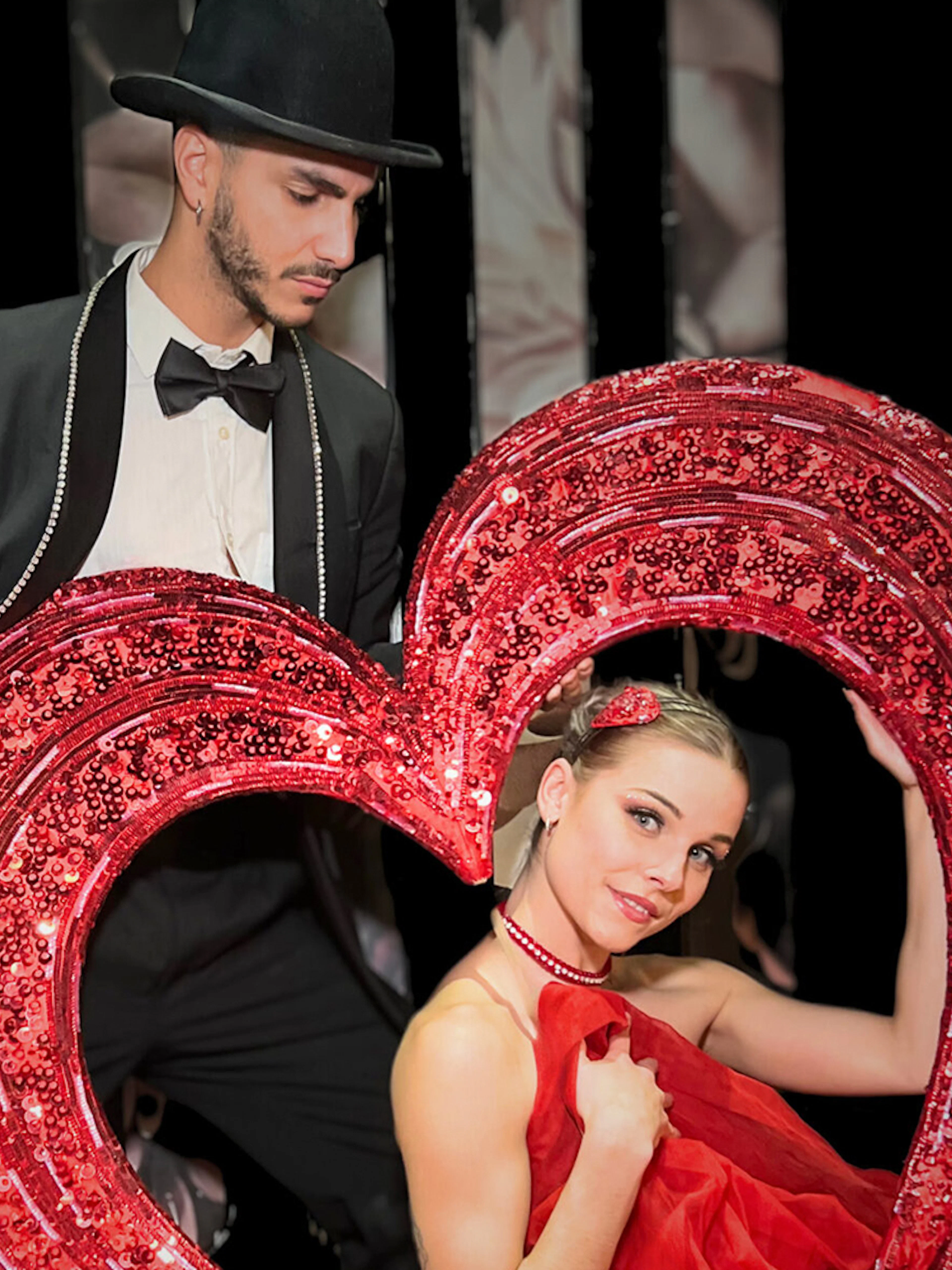 Performers with a heart prop at Saint Valentine's Day Paradis Latin show.
