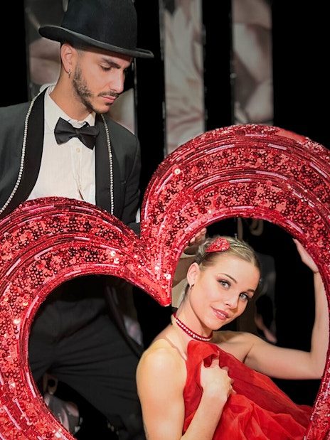 Performers with a heart prop at Saint Valentine's Day Paradis Latin show.