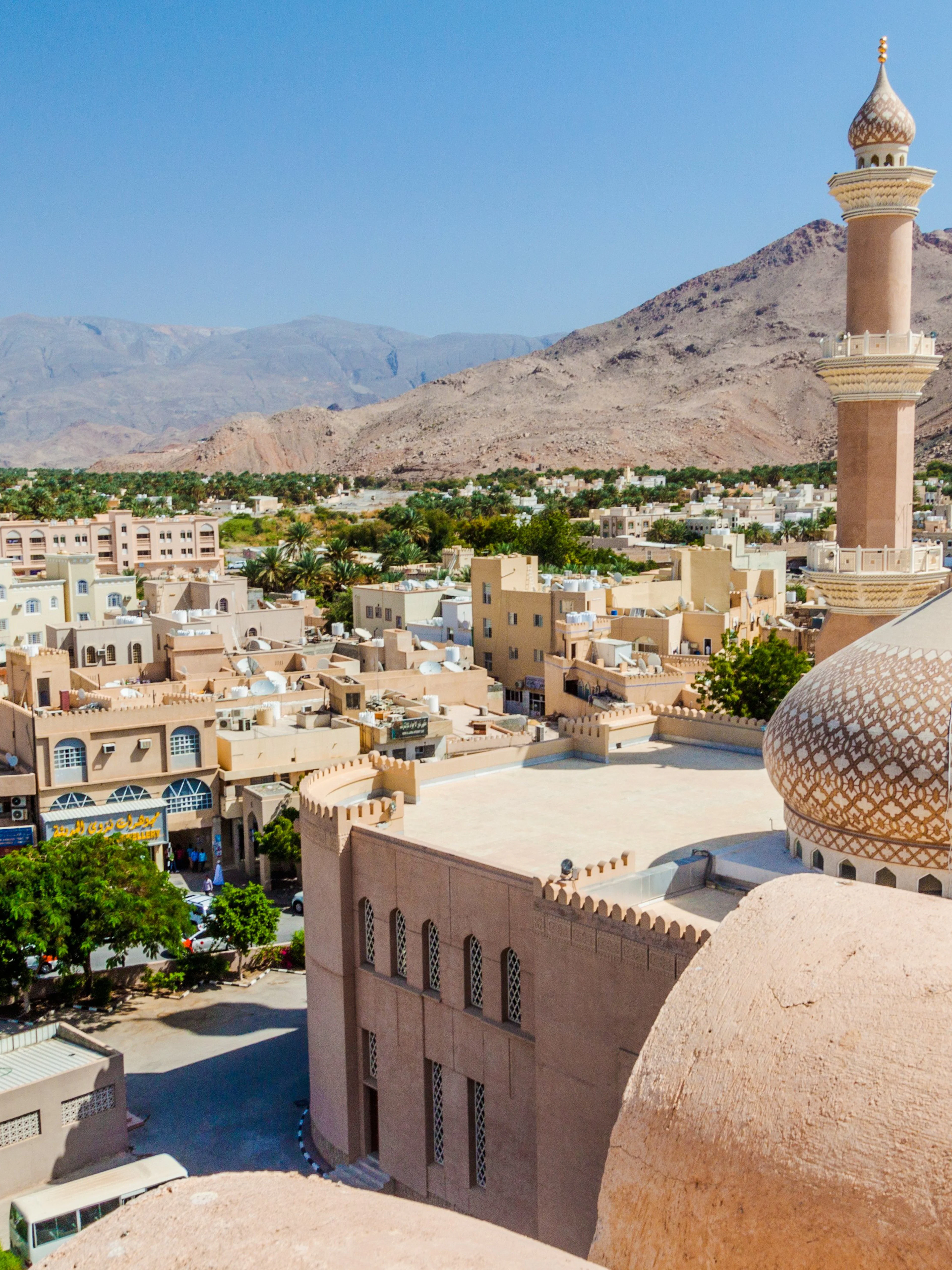 Aerial view of Nizwa with Sultan Qaboos Mosque and surrounding mountains, Oman.