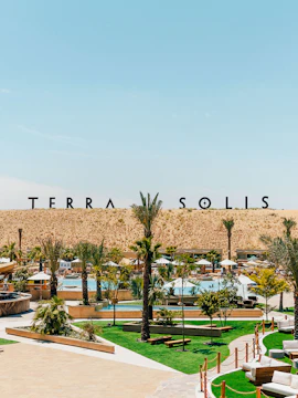 Terra Solis resort with pool, palm trees, and desert backdrop.