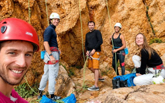 Group preparing for rock climbing in Guia Cascais with ropes and helmets.