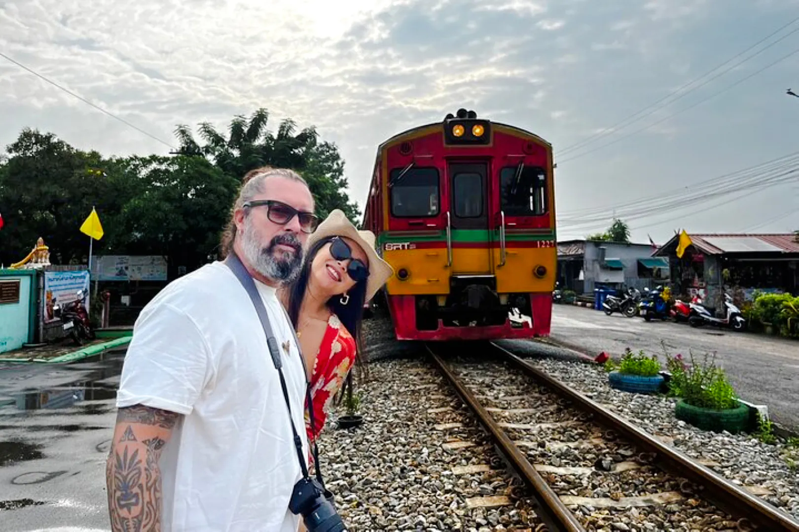 Tourists at Maeklong Railway Market with train approaching, part of Floating Market & Railway Market tour from Laem Chabang.