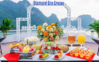 Luxury dining setup on Ha Long Bay's Diamond Era Cruise with floral centerpiece and refreshments.