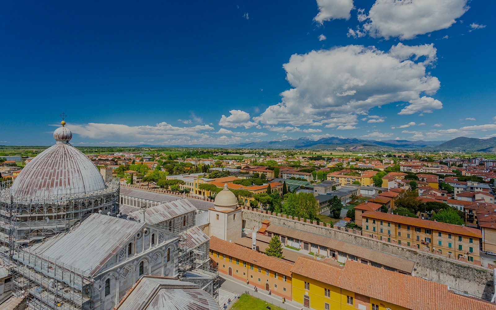 View from the Leaning Tower in Pisa overlooking the cityscape and cathedral dome.