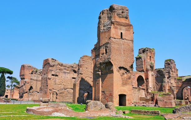 Ancient ruins of the Baths of Caracalla in Rome under a clear blue sky.