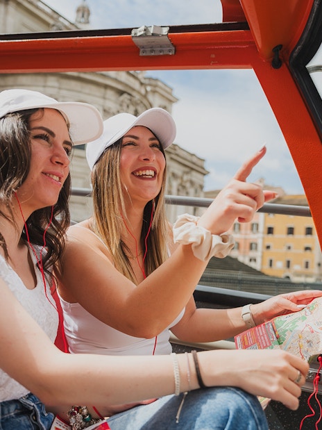 Passengers enjoying a City Sightseeing bus tour, viewing landmarks with a map.