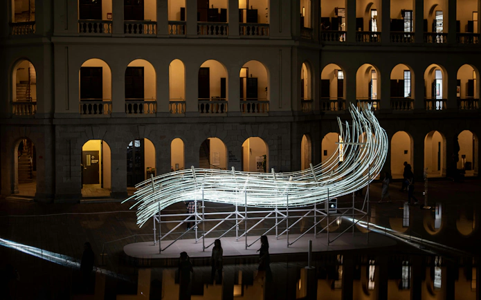 Amsterdam Light Festival installation with illuminated sculpture in front of historic building.