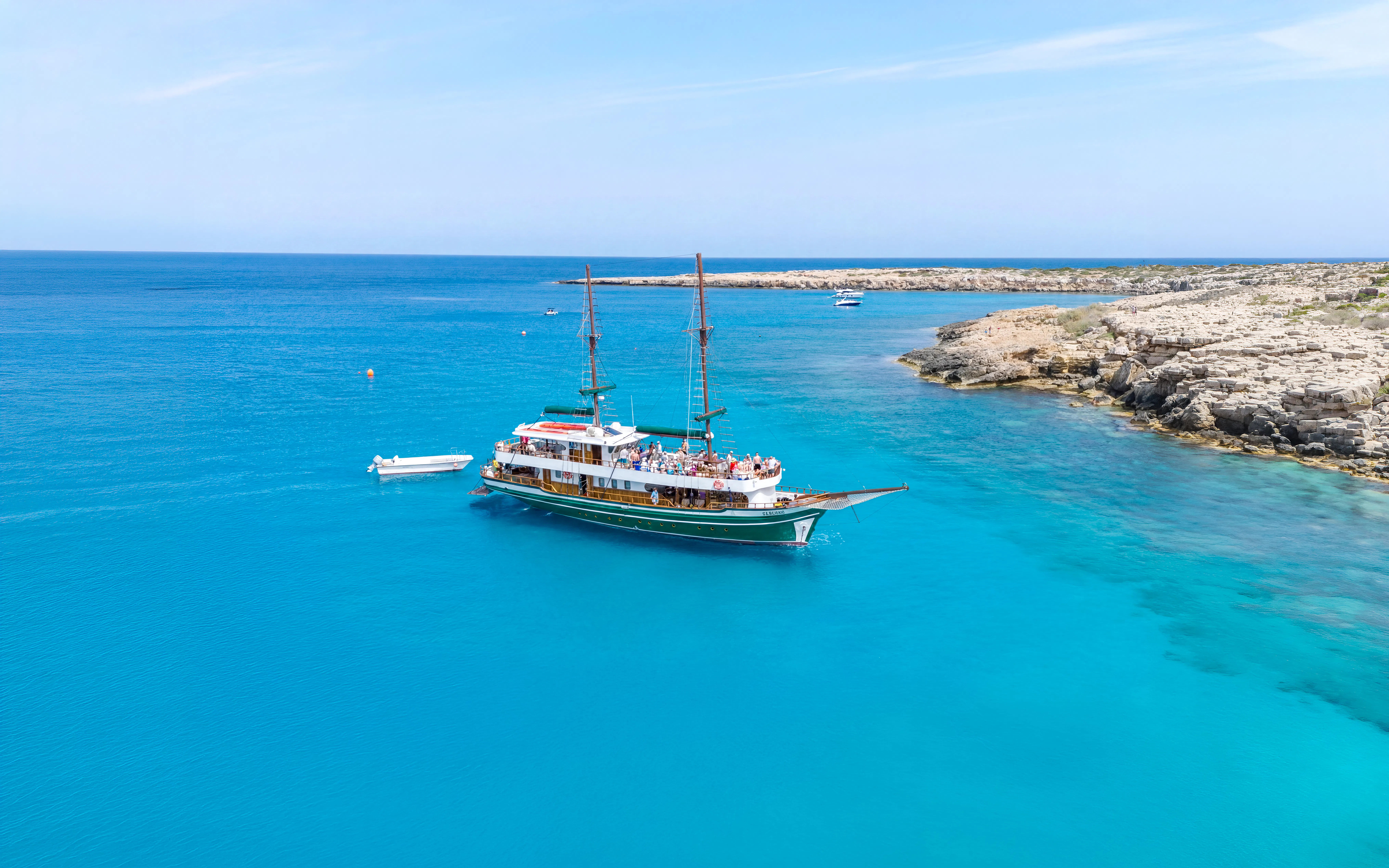 Sailing boat near rocky coastline in Blue Lagoon, Protaras, Cyprus.