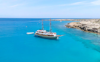 Sailing boat near rocky coastline in Blue Lagoon, Protaras, Cyprus.