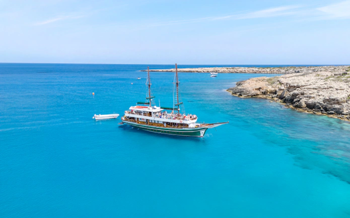 Sailing boat near rocky coastline in Blue Lagoon, Protaras, Cyprus.