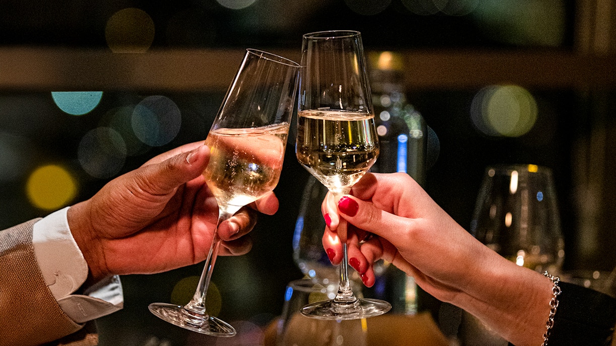 Couple toasting with champagne at Madame Brasserie Eiffel Tower Restaurant.