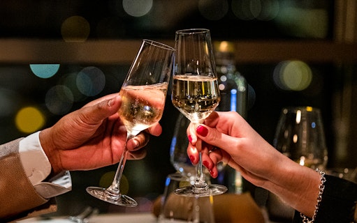 Couple toasting with champagne at Madame Brasserie Eiffel Tower Restaurant.