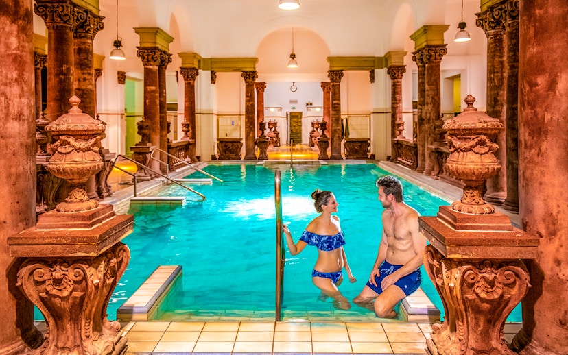 Indoor pool with ornate columns at Széchenyi Spa, Budapest.