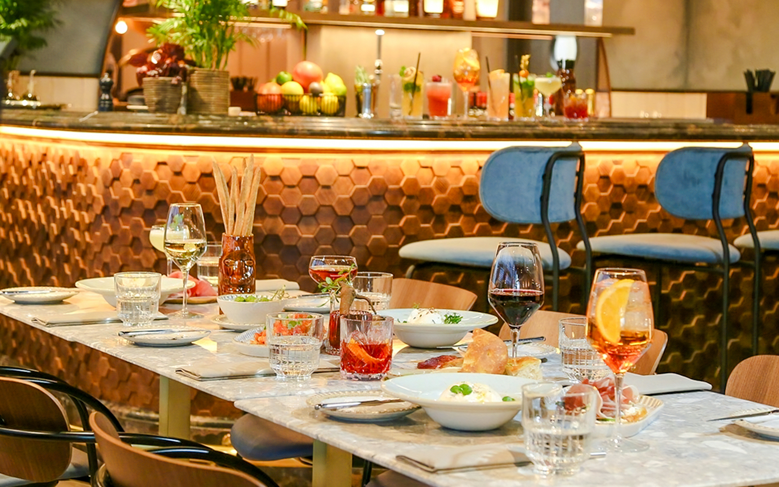 Dinner setting at The Larch, Sky Garden London, with wine glasses and dishes on a marble table.