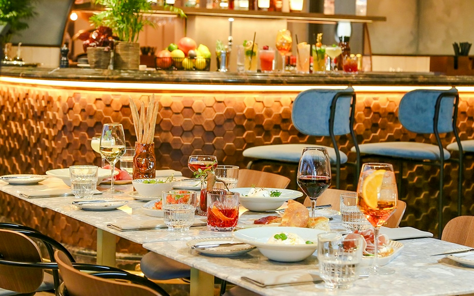 Dinner setting at The Larch, Sky Garden London, with wine glasses and dishes on a marble table.