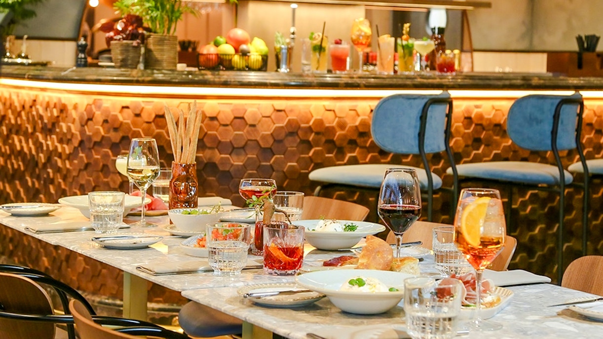 Dinner setting at The Larch, Sky Garden London, with wine glasses and dishes on a marble table.