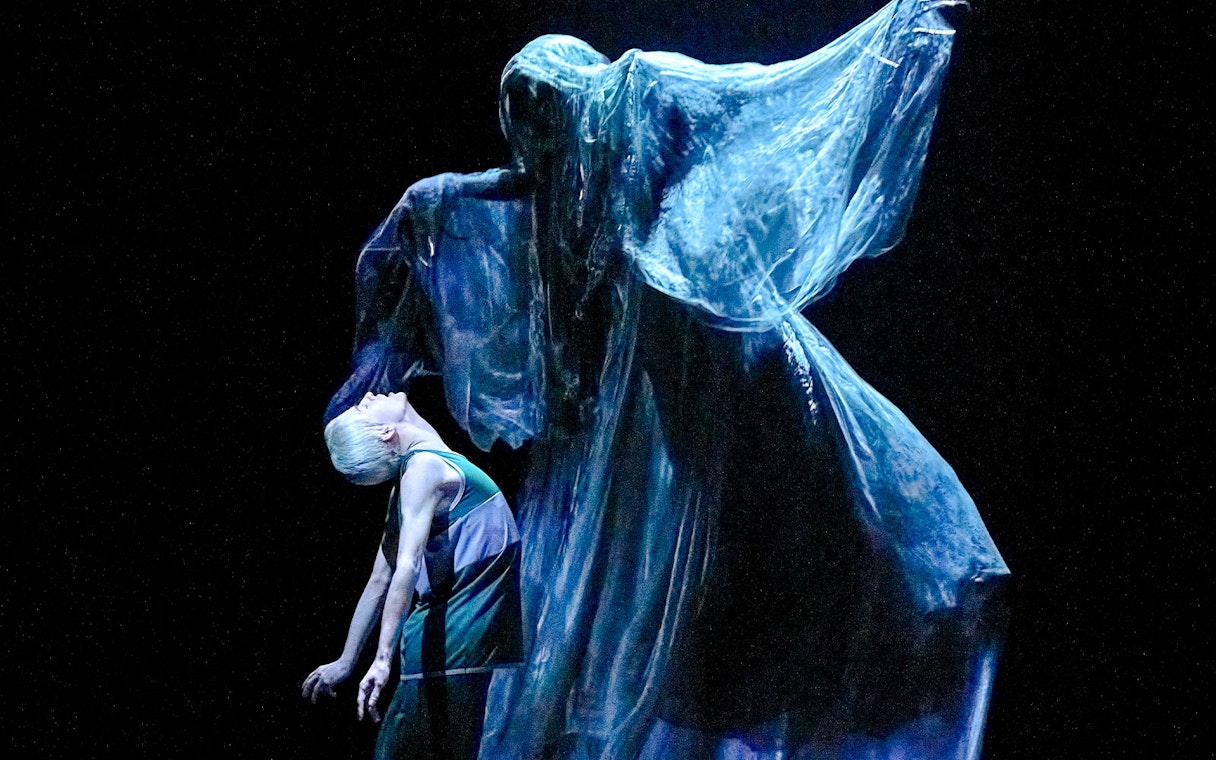 Stage scene from "Harry Potter and the Cursed Child" with a ghostly figure looming over a character.