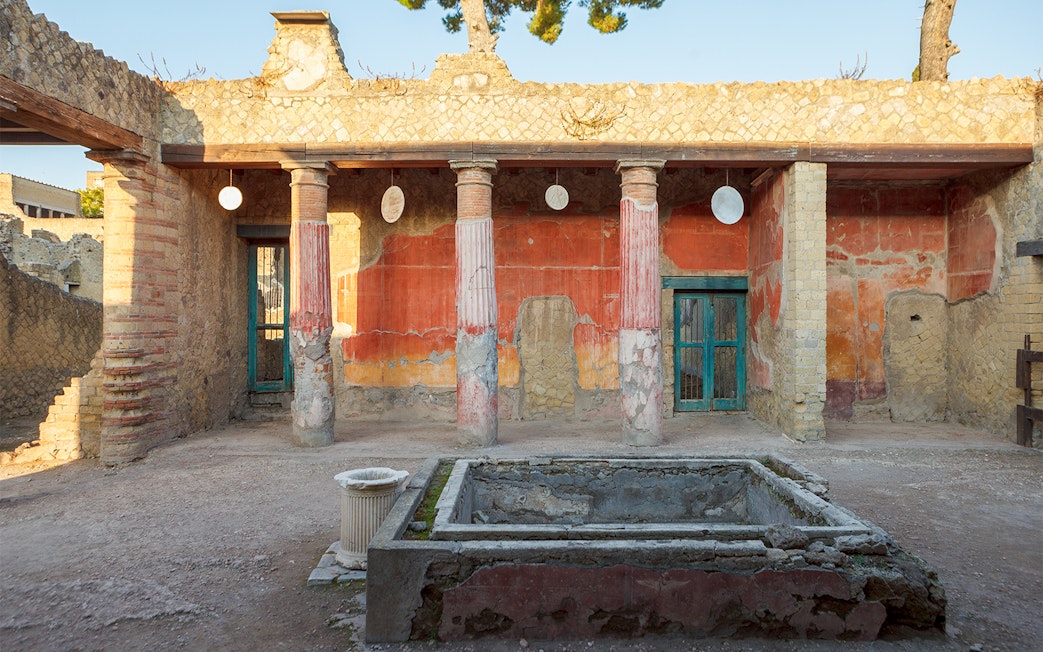 Ancient Herculaneum ruins with preserved columns and frescoes in Italy.