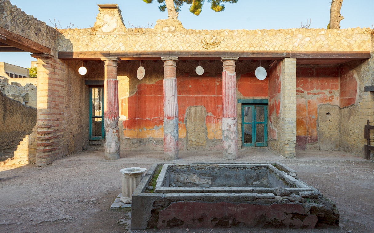 Ancient Herculaneum ruins with preserved columns and frescoes in Italy.