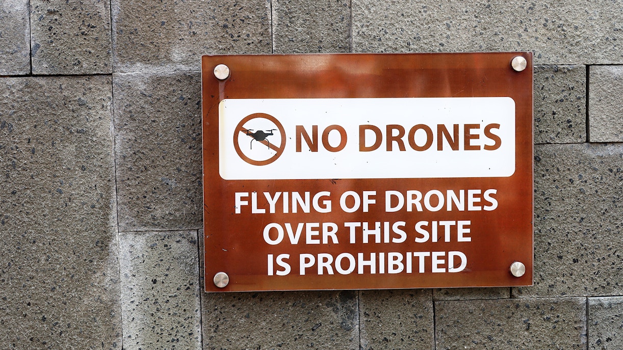 Drones prohibited sign at tourist attraction, highlighting rules and regulations.