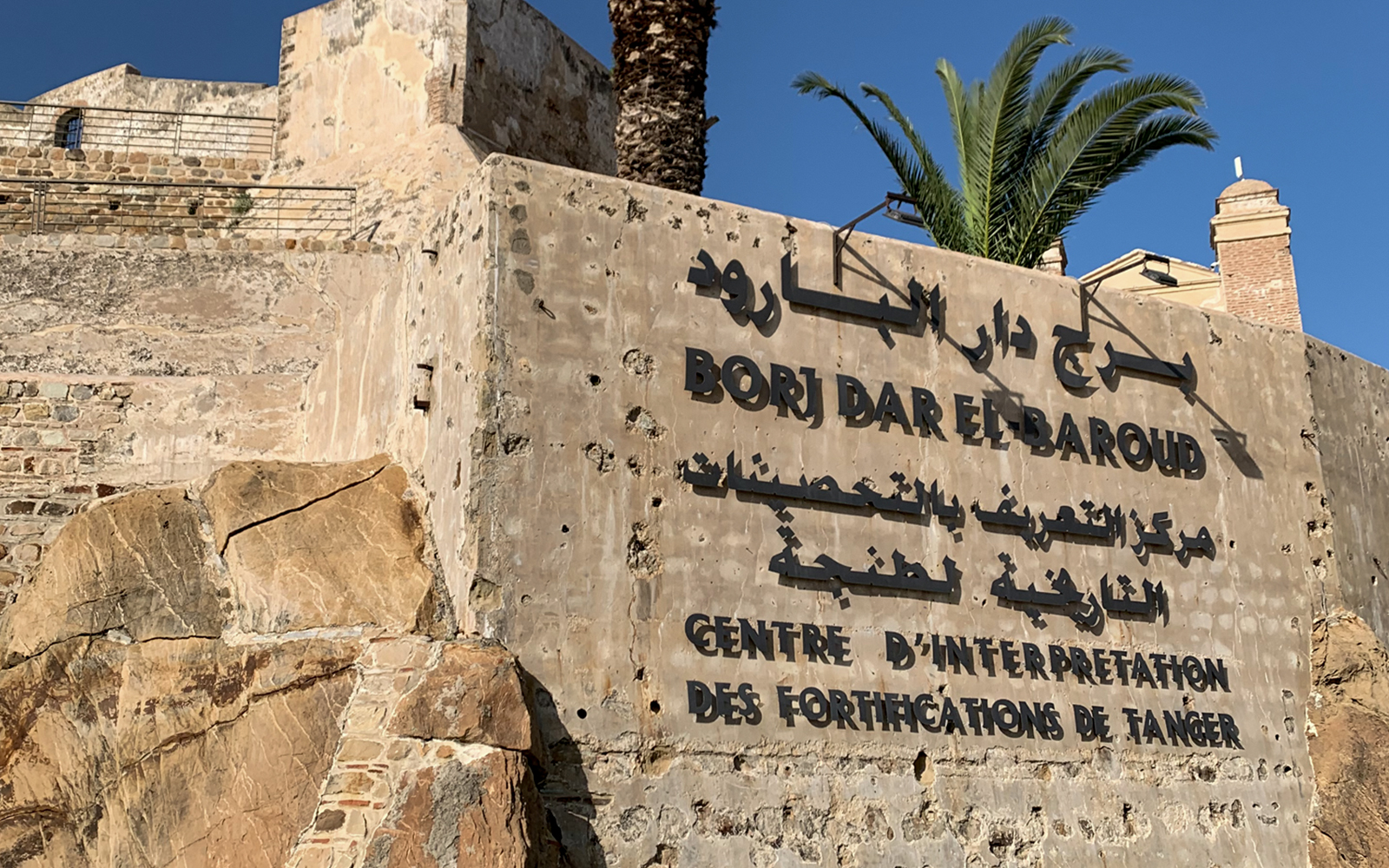 Borj Dar El Baroud fortification wall in Tangier, Morocco, with historical signage.