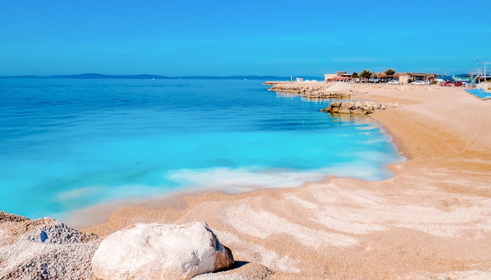Beach with crystal blue water and rocky shoreline near Split, Croatia.