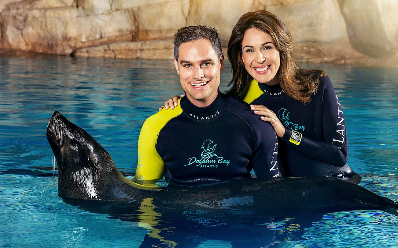 Couple with sea lion at Dolphin Bay, Atlantis Dubai.