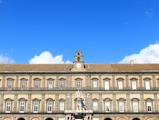 Palazzo Reale in Naples with visitors in the courtyard.