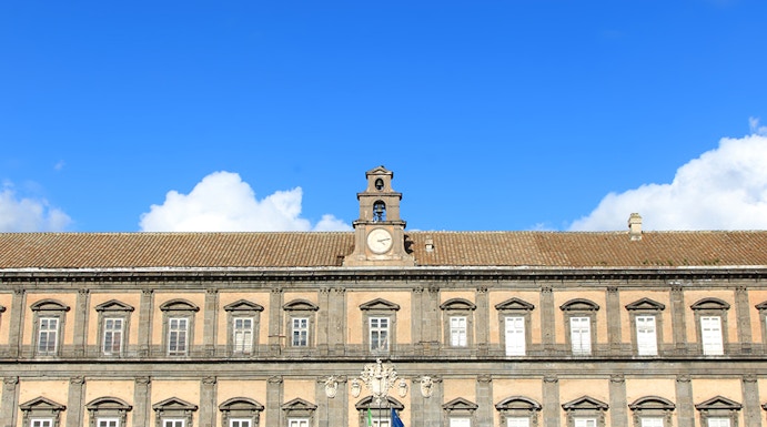 Palazzo Reale in Naples with visitors in the courtyard.