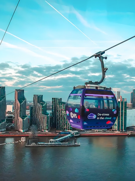 London IFS Cable Car over River Thames with city skyline in the background.
