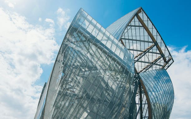 Fondation Louis Vuitton building with glass panels in Paris.