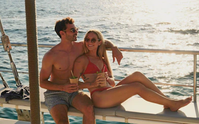 Couple relaxing with drinks on a boat at sunset in Mallorca.