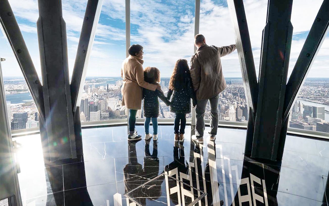 Family viewing New York City skyline from Empire State Building observatory.