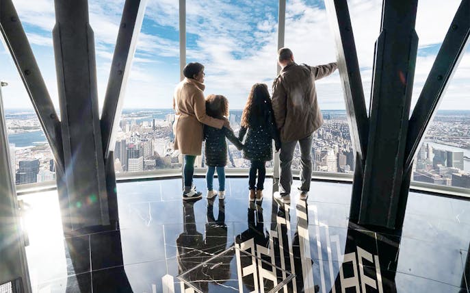 Family viewing New York City skyline from Empire State Building observatory.