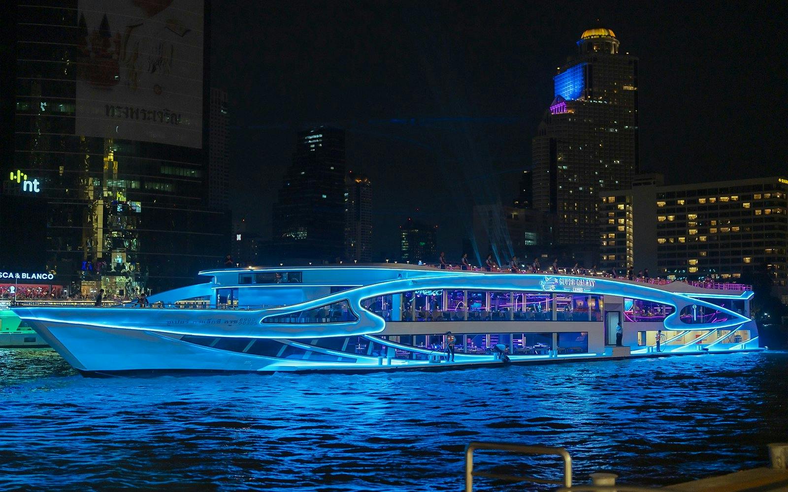 Luxury dinner cruise on Chao Phraya River, Bangkok, with city skyline at night.