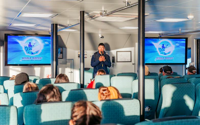 Guide giving a presentation on a whale watching cruise in Kaikoura, New Zealand.