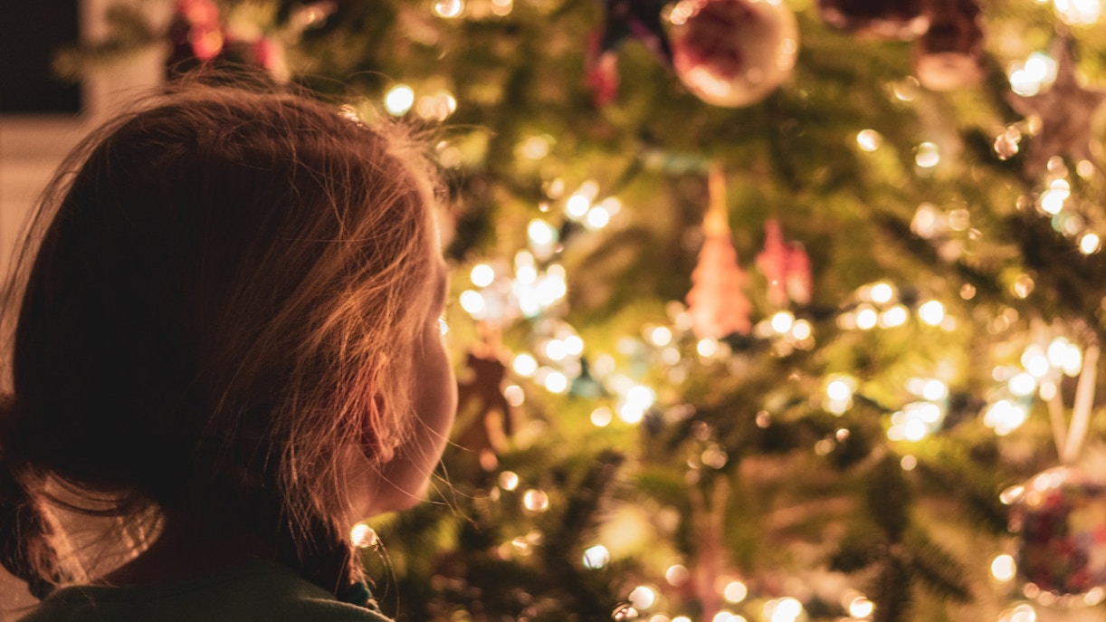 Child admiring Christmas tree lights and ornaments, Buckingham Palace tour.